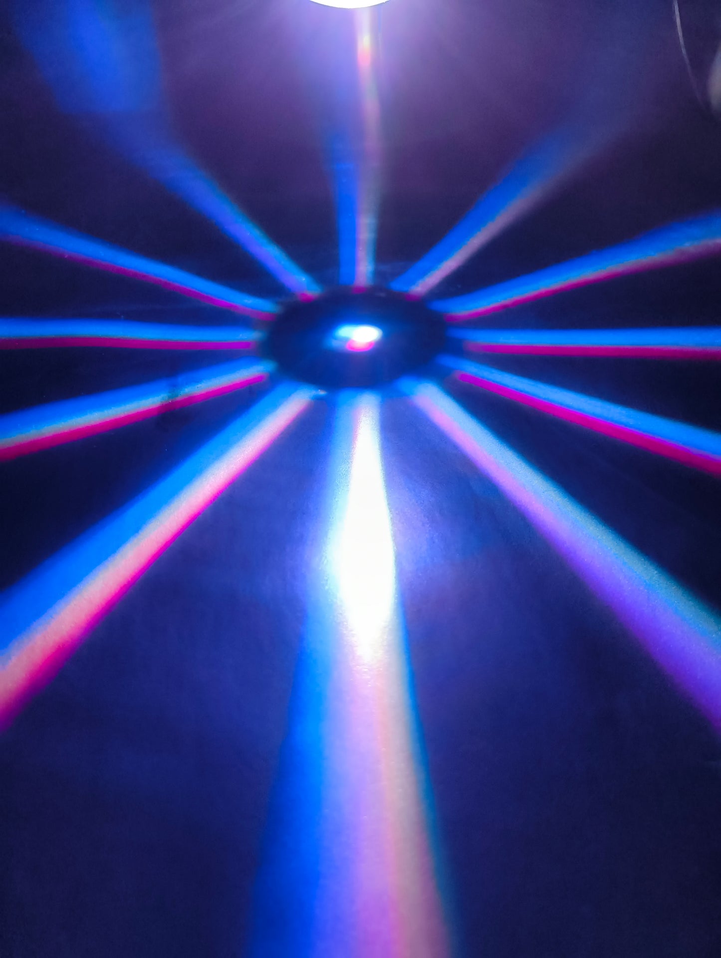 Colorful light beams radiating from a central point on a dark background