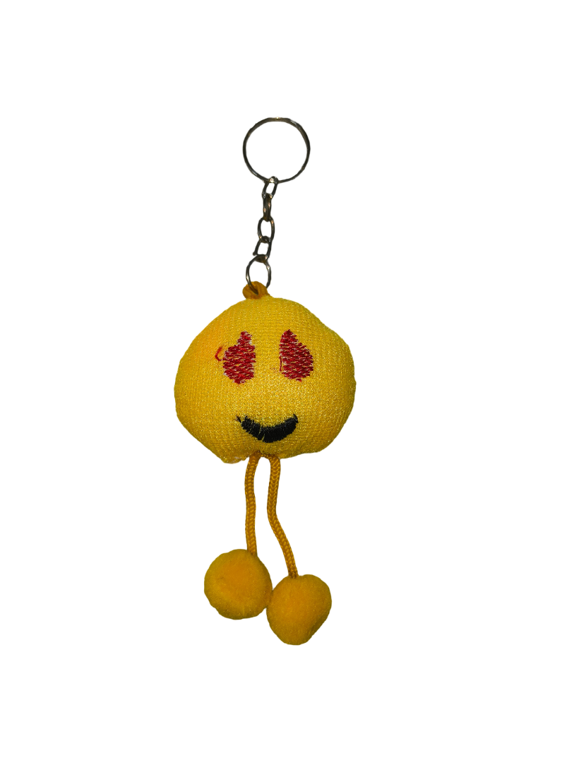 Yellow plush keychain with a smiling face and red blush marks on a white background