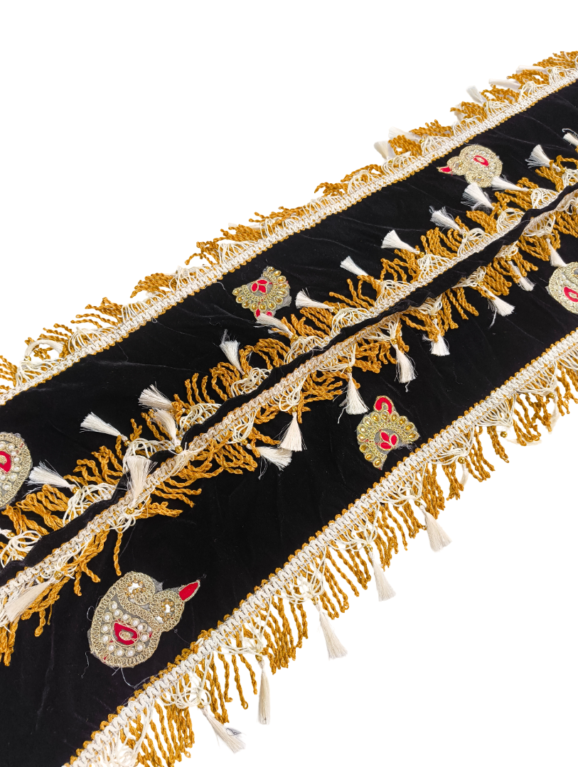 Decorative black fabric with gold embroidery and tassels on a white background