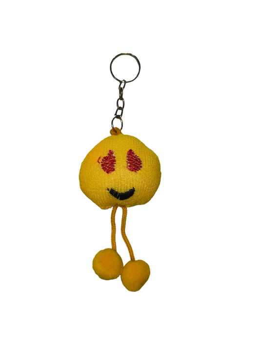 Yellow plush keychain with a smiling face and red blush marks on a white background
