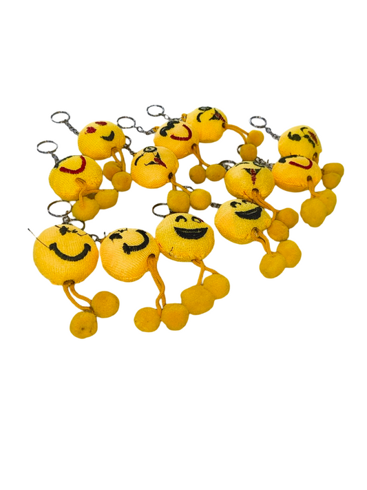 Set of yellow smiley face keychains on a white background